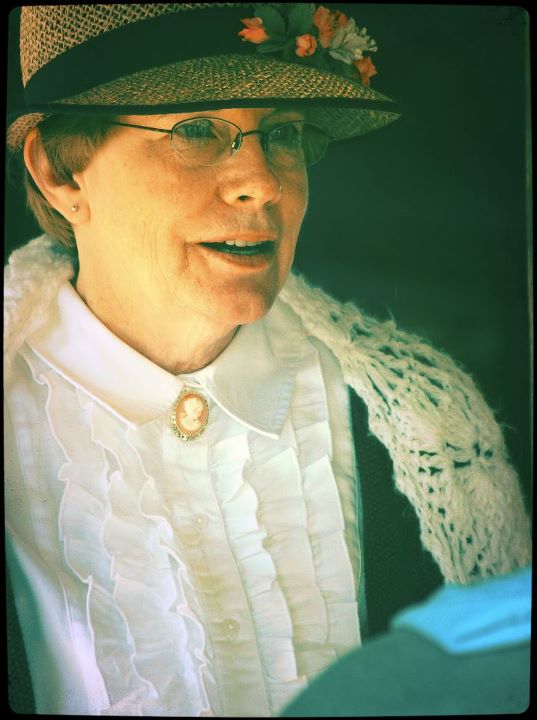 A woman wearing a hat and historical re-enactment clothing in an American Pioneer style.